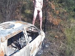 Guy is ejaculating on top of burned car